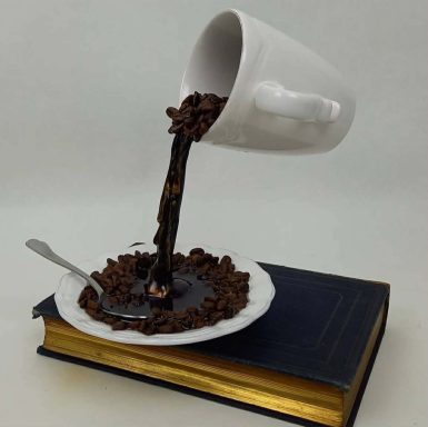 Trompe l’œil tasse café qui coule sur un livre, sculpture